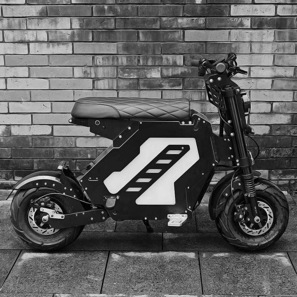 A side view of an electric motorbike with a minimalist, geometric design, parked in front of a brick wall. The bike features a quilted seat and sleek bodywork, showcasing modern urban styling.