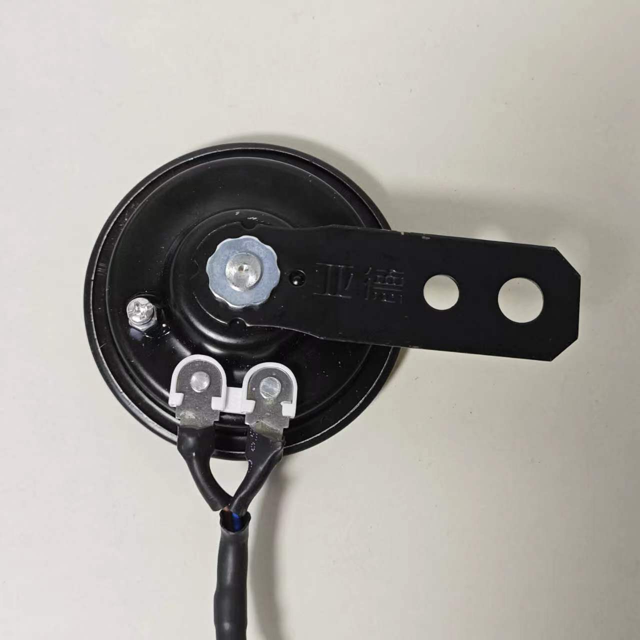 The black electric motorcycle horn, rated at 105 dB for 12V systems, is clearly marked to indicate its specifications. A single mounting point ensures it can be easily installed on a wide range of motorcycle models, making it a must-have accessory for any electric motorcycle.