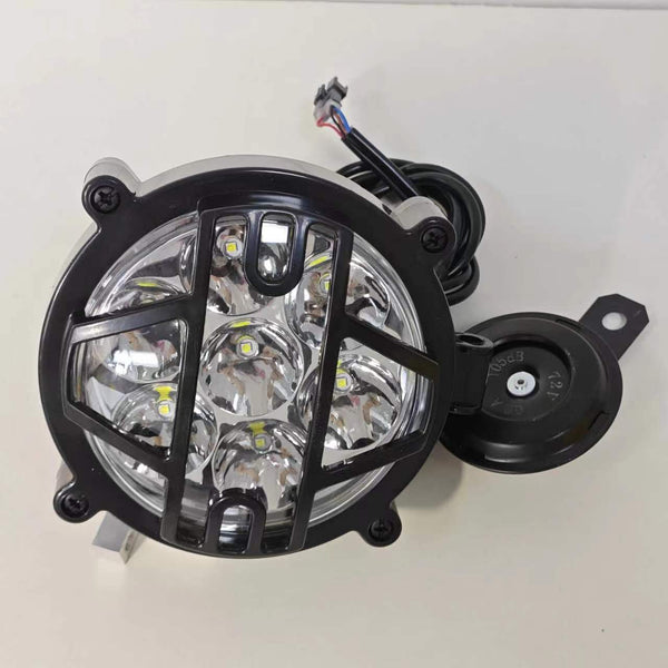 The electric motorcycle is equipped with a headlight and horn. These bulbs are arranged in a circle and are located in a solid black grille, which provides protection and creates a stylish look. A horn is mounted on the side for safety.