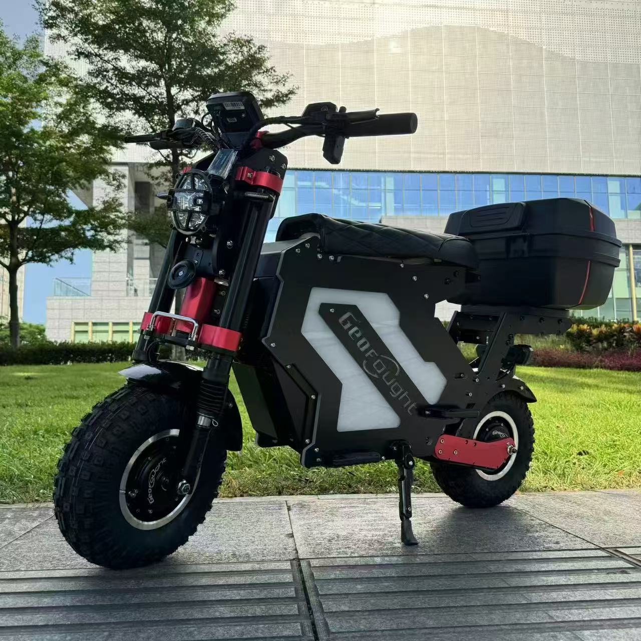  A side view of a mini electric motorcycle off-road version with enhanced features including a rear trunk, displayed on a city pathway.