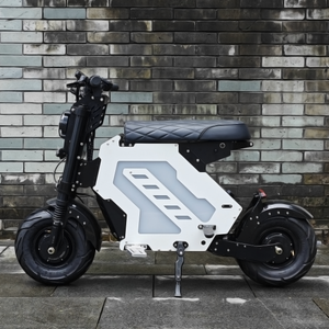 A side view of an electric motorbike with a quilted seat and modern design, parked against a patterned brick wall. The bike showcases a unique and geometric aesthetic suitable for urban commuting.