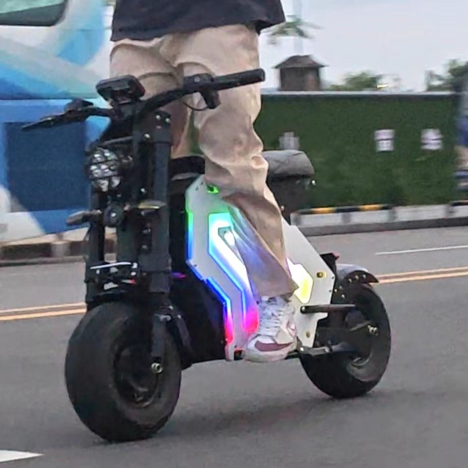 "Yisuntrek electric scooter moving fast on city streets in the evening with colorful LED lights and modern design side view